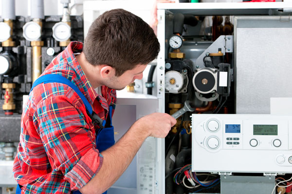 Heating technician repairing boiler controls in Santa Monica