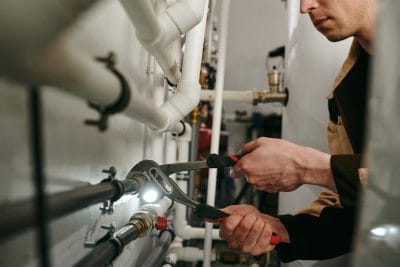 Technician inspecting commercial plumbing pipes in Santa Monica