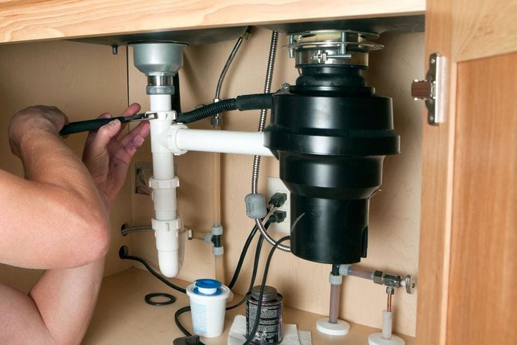 Plumber repairing a garbage disposal in Santa Monica