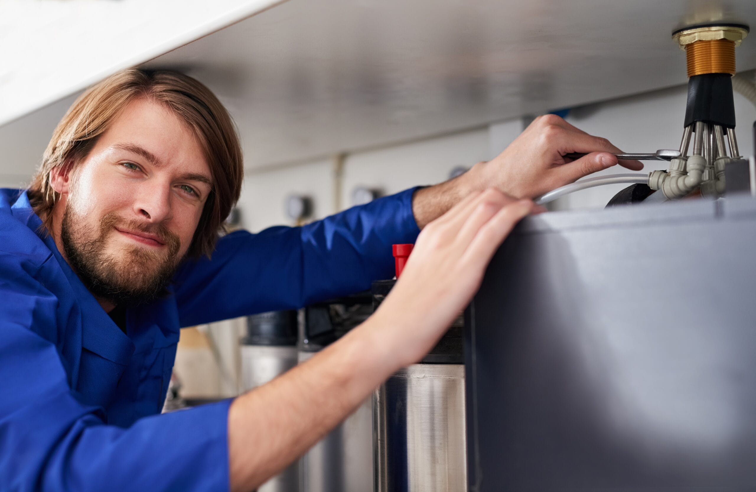 Technician servicing a residential water heater tank in Santa Monica